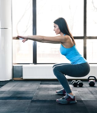 Side view portrait of a young woman doing squats at fitness gym-2